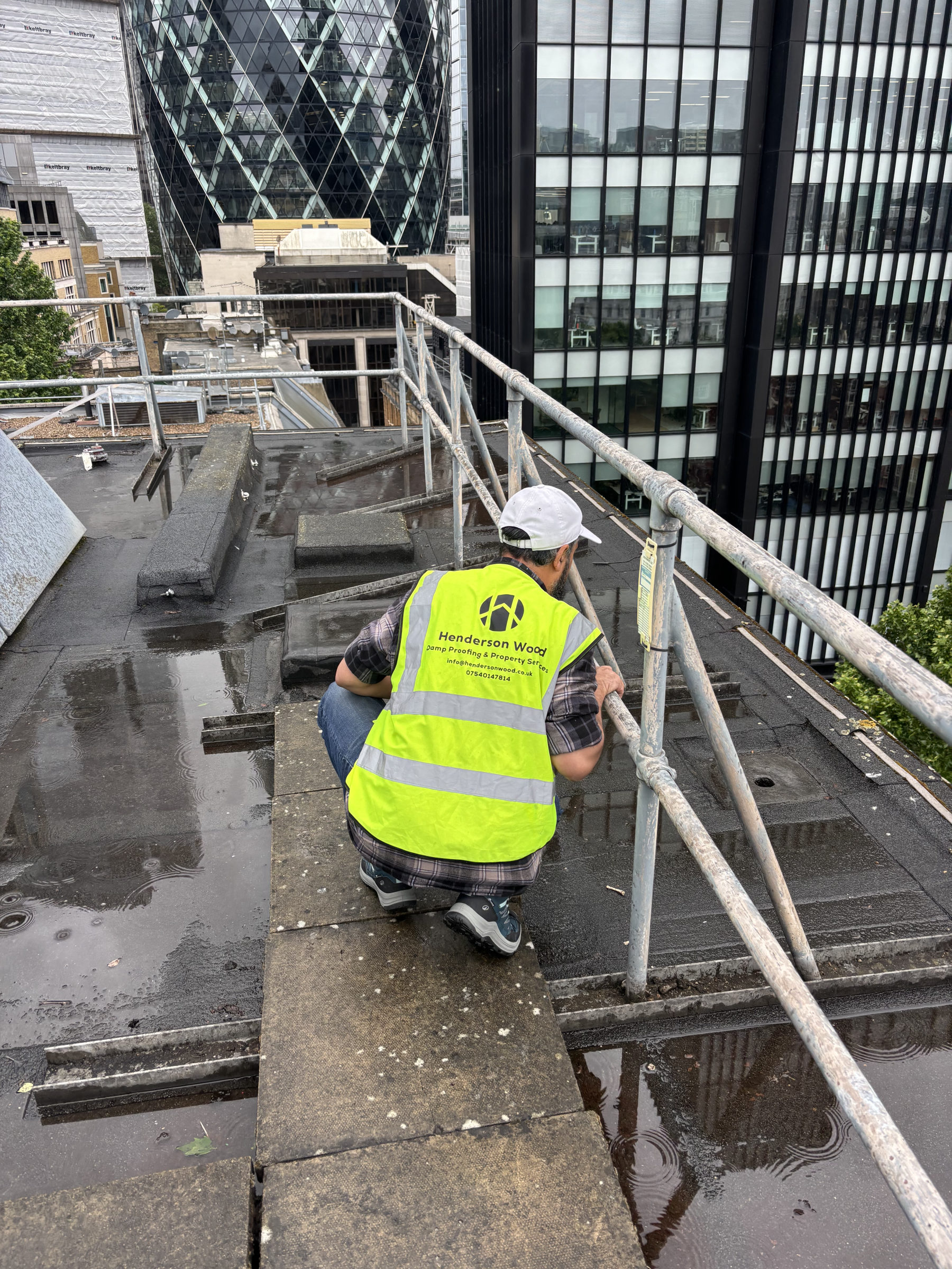 Henderson Wood surveyor inspecting a commercial rooftop parapet in the City of London