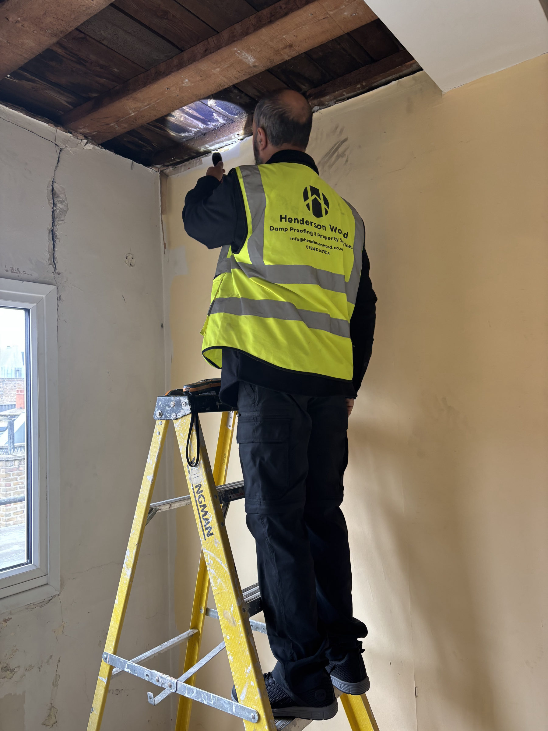 Torch inspection of a water-damaged ceiling void during a water damage survey
